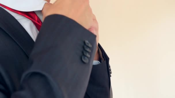 zakenman rechtzetten een rode stropdas. 4 k, vertraagd, super close-up. kopie ruimte - Video