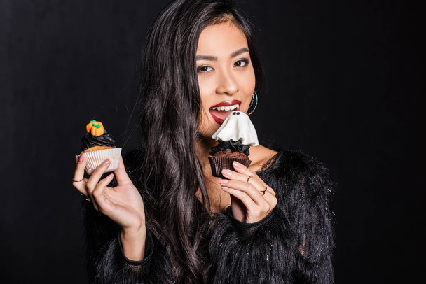 mujer sosteniendo dos cupcakes
 - Foto, imagen