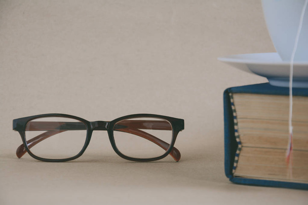 Książka okulary i herbata na biurku z praktyczno badania i edukacja - Zdjęcie, obraz