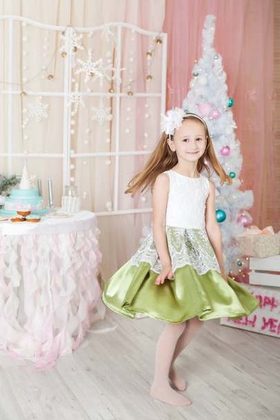 Cute girl in a Christmas decorated studio in pastel colors - Foto, Imagem