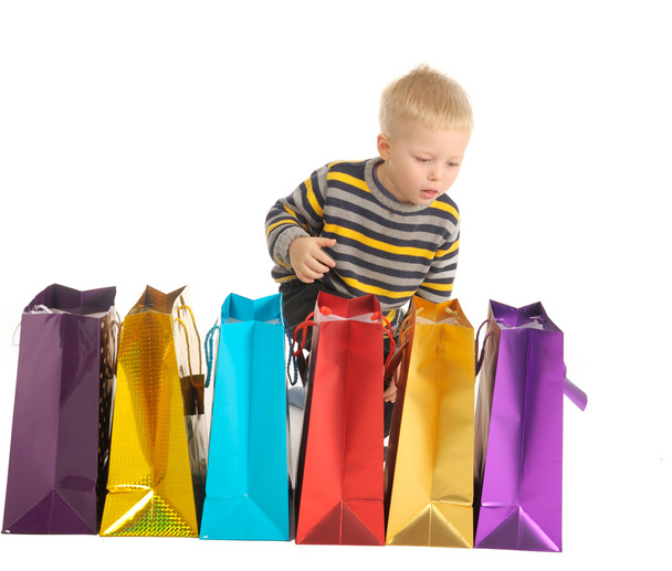 Cute boy with shopping bags after shopping. isolated on white - 写真・画像