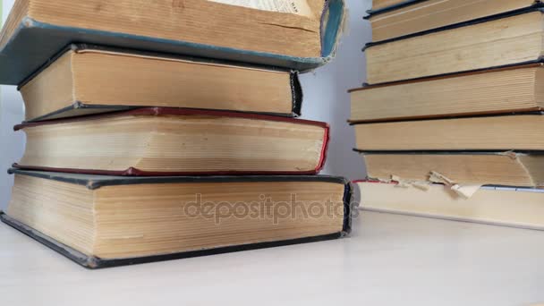 Estudiante mira en pila de libros en la mesa
 - Imágenes, Vídeo
