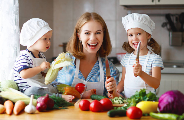 Healthy eating. Happy family mother and children  prepares   vegetable salad - Photo, Image