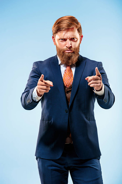 Portrait of a business man isolated on blue background. - 写真・画像