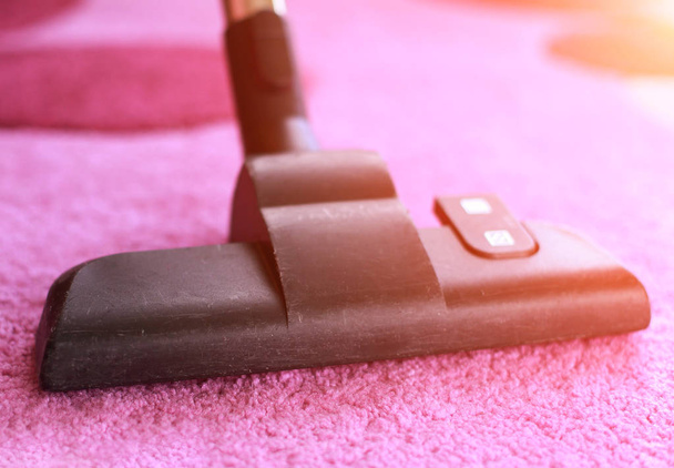 Vacuum cleaning with hoover on rug - Foto, afbeelding