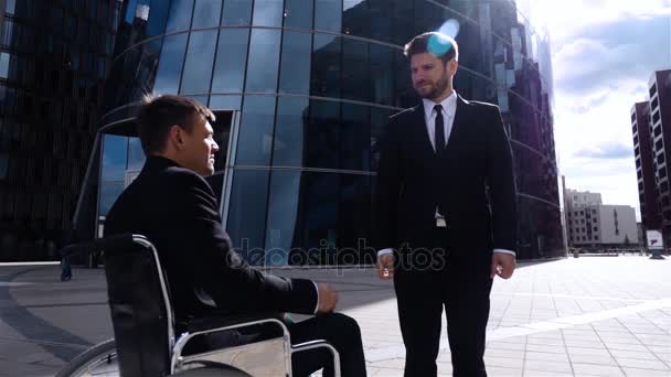 Empresario feliz sacudiendo las manos con empresario discapacitado al aire libre
 - Metraje, vídeo