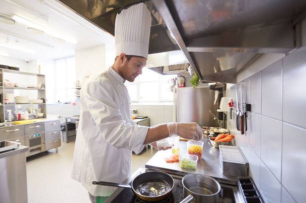 chef masculino feliz cozinhar comida na cozinha do restaurante
 - Foto, Imagem