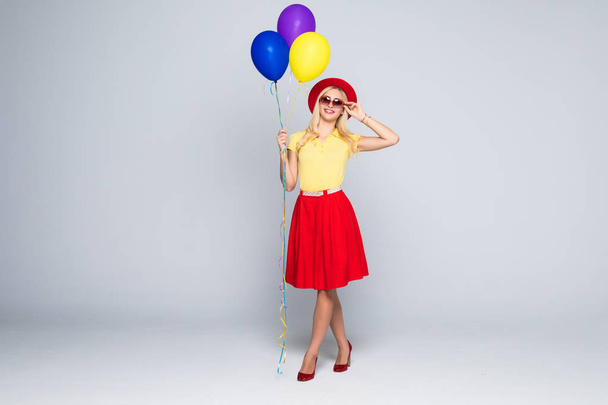 Fashion pretty woman with yellow air balloon over colorful gray background full height - Фото, зображення