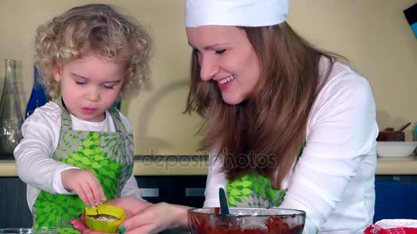 Šťastné milující matka a dcera připravuje cupcakes v kuchyni - Záběry, video