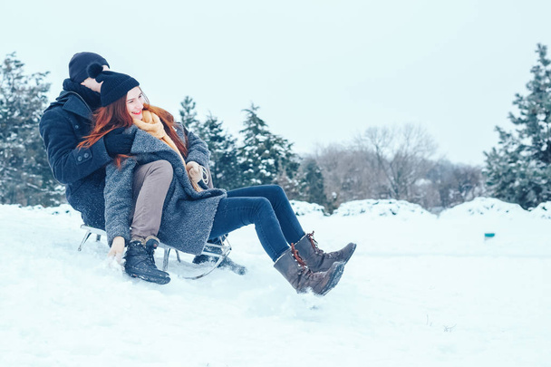恋冬の休暇を楽しんでいると、雪の降る冬の日に楽しんで若いカップル. - 写真・画像