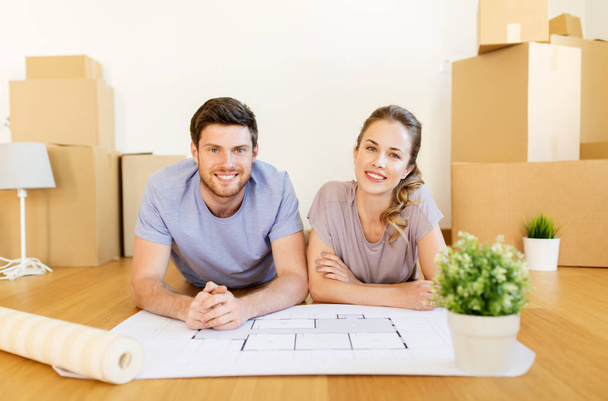 couple with boxes and blueprint moving to new home - Valokuva, kuva