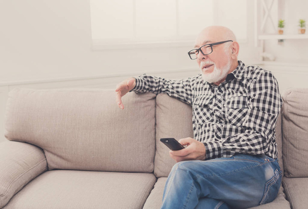 Senior man kijken tv kopie ruimte rust - Foto, afbeelding