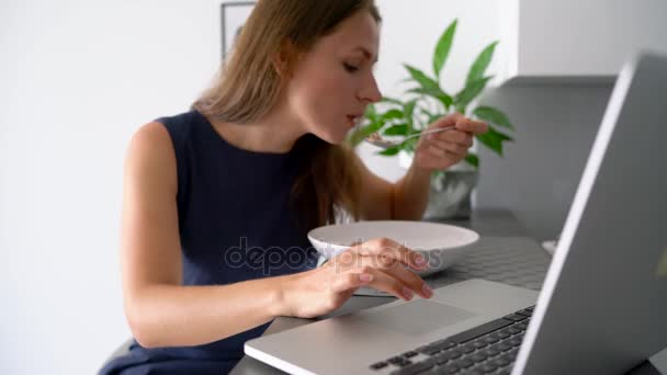 Attractive woman using her laptop while having a breakfast - Metraje, vídeo
