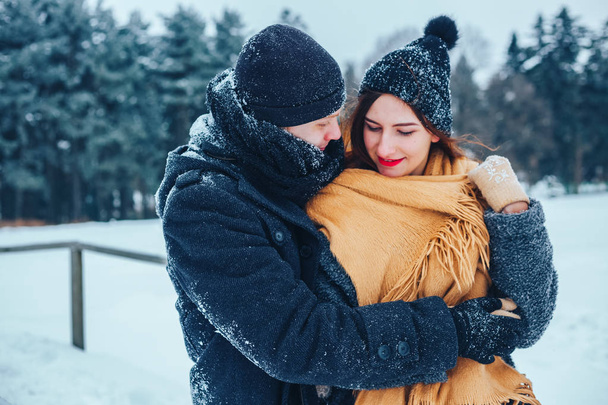Mies ja tyttö lepäävät talvimetsässä. Aviomies ja vaimo lumessa. Nuori pari kävelee talvipuistossa. - Valokuva, kuva