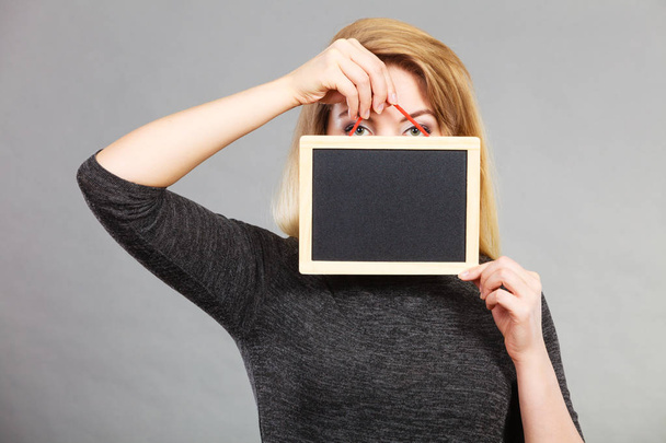 Woman holding blank black board on face - Foto, Bild