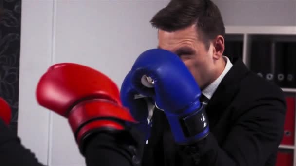 Dos hombres de negocios boxeando en la sala de oficina
 - Metraje, vídeo