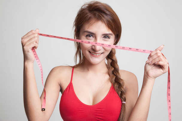 Beautiful Asian healthy girl with measuring tape. - Фото, изображение