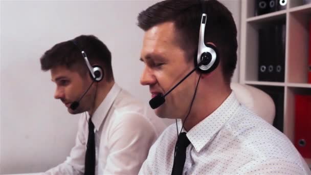 zwei Männer mit Kopfhörern im Gespräch über Anrufzentrale - Filmmaterial, Video