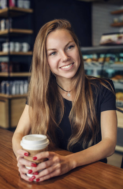 Hermosa mujer con una taza de café sonriendo
 - Foto, Imagen