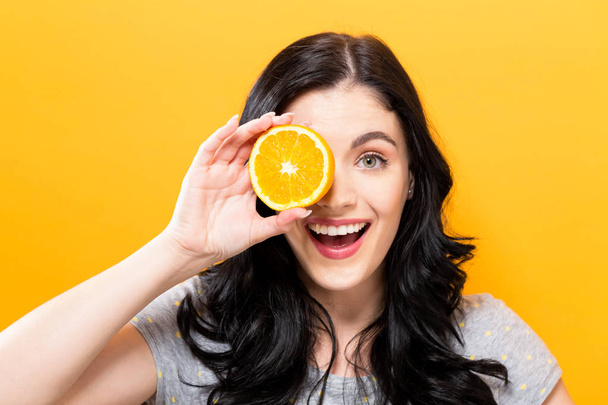 Happy young woman holding oranges  - 写真・画像