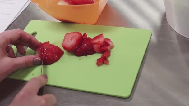 Руки женщины режут клубнику на доске на кухне на металлическом столе
 - Кадры, видео