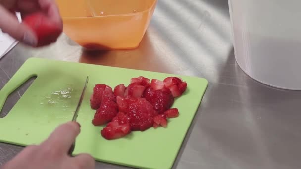 Kobieta ręce kawałki truskawka na deski do krojenia w kuchni na stół metalowy - Materiał filmowy, wideo