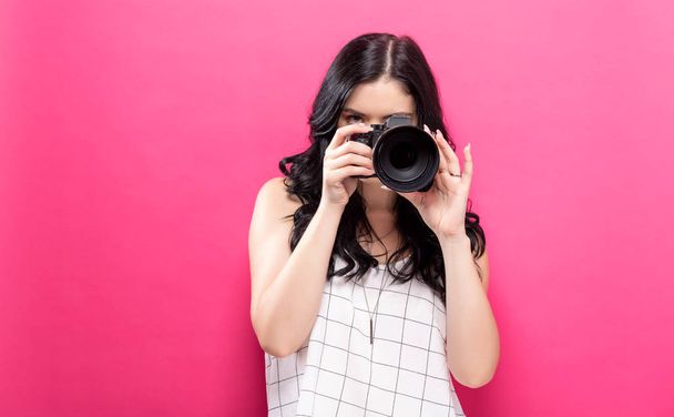  Young woman holding a camera  - 写真・画像