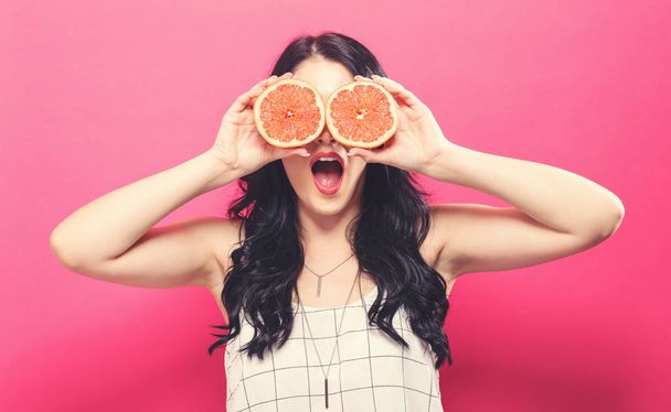 Happy young woman holding oranges  - Foto, Bild
