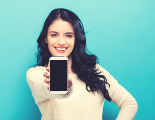 Young woman holding out a cellphone - Photo, Image