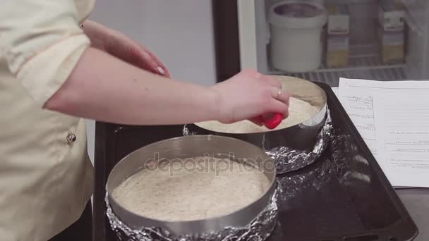 Θηλυκό ζαχαροπλαστικής chef χρησιμοποιώντας σπάτουλα κερασάκι στην ομαλή ζύμη στο ταψί - Πλάνα, βίντεο