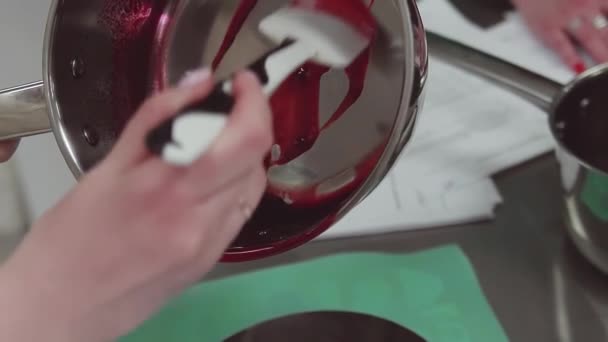 Кондитер кладет кипяченые ягоды в блюдце, используя лопатку на кухне
 - Кадры, видео