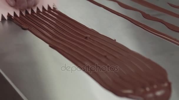Confeiteiro fazendo sulcos em tira de chocolate usando raspador de plástico
 - Filmagem, Vídeo