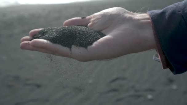 Руки з чорним піском на пляжі Ісландії. - Кадри, відео