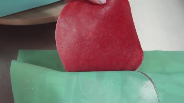 Vrouwelijke banketbakker hand neemt ronde gelei taart tussenlaag, zet het op vla - Video