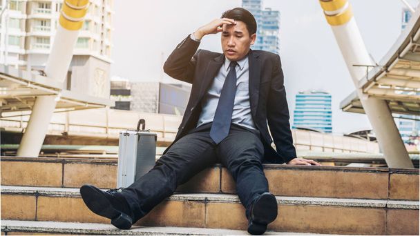 Отчаянный бизнесмен безнадежно сидит на лестничном полу
 - Фото, изображение