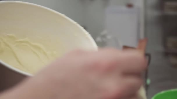 Cukrász kézzel hozza tésztát Muffin pergamen poharak a tepsibe - Felvétel, videó