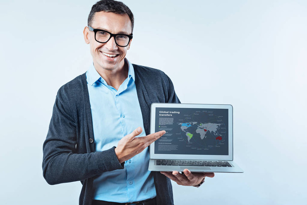 Smart man showing laptop with global trading transfers - Photo, Image