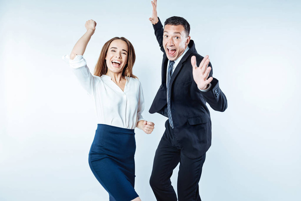 Excited coworkers jumping high while cannot keep their emotions inside - Φωτογραφία, εικόνα