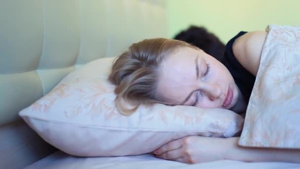 Young sleeping woman frowns in bed in early morning - Footage, Video