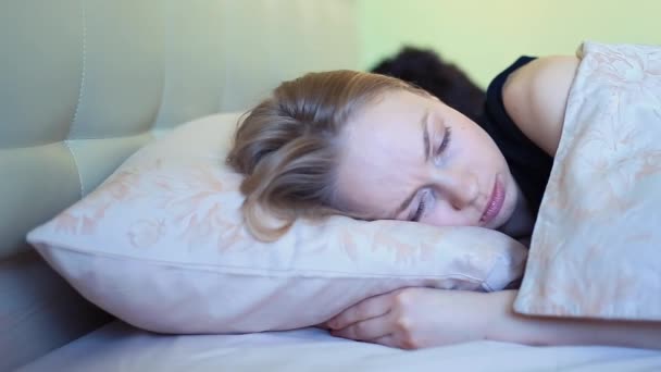 Joven mujer dormida habla con su novio en la cama por la mañana temprano
 - Metraje, vídeo