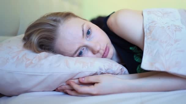 Mujer joven con ojos azules habla con su novio acostado en la cama temprano en la mañana
 - Imágenes, Vídeo