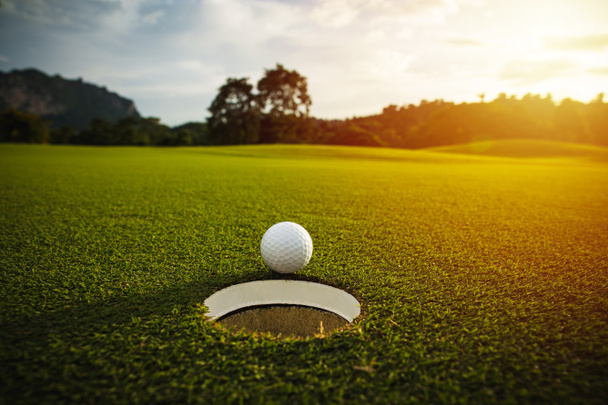 selektivní zaměření. bílý golfový míček u otvoru na zelené trávě dobrý f - Fotografie, Obrázek