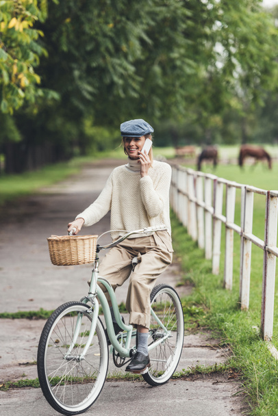 woman with smartphone on bicycle  - Фото, зображення