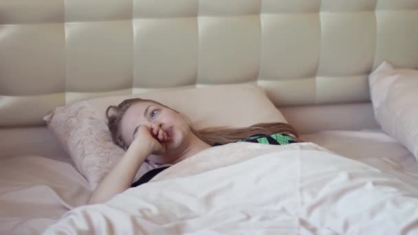 Attractive sluggish blonde girl gets out bed in early morning - Filmati, video