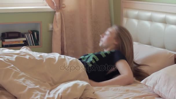 Young lazy blonde woman gets out bed in early morning - Materiał filmowy, wideo