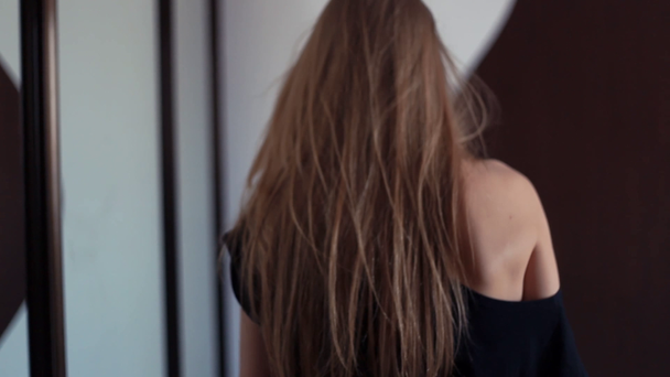 Jonge aantrekkelijke vrouw loopt naar de lade in de woonkamer, pikt kleding - Video