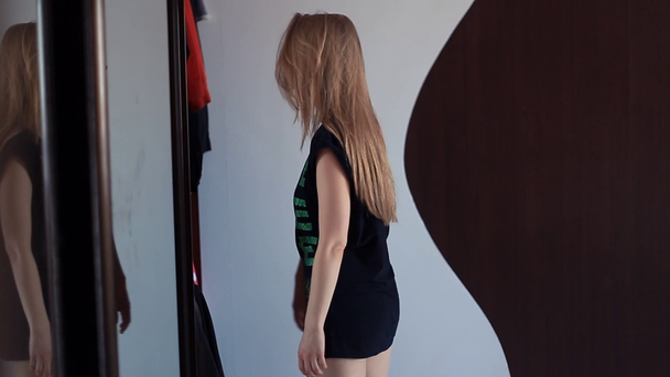 Jonge sexy meisje opent spiegel lade deur, het kiezen van kleding in de ochtend - Video