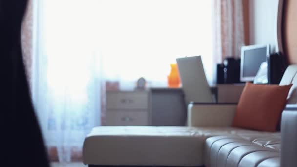 Młoda kobieta rzuca sukienka na kanapie w salonie w wcześnie rano - Materiał filmowy, wideo