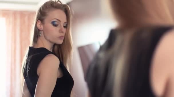 Ελκυστική ξανθιά παιχνιδιάρικο κοπέλα ψάχνει σε καθρέφτη, αποστολή αέρα φιλιά - Πλάνα, βίντεο