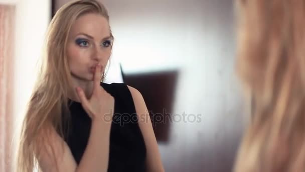 Mladá krásná hravá blondýnka při pohledu do zrcadla, send vzduch polibky - Záběry, video